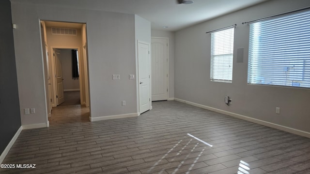 unfurnished bedroom featuring visible vents, baseboards, and wood finished floors