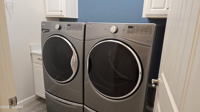 laundry area with wood finished floors, independent washer and dryer, baseboards, and cabinet space