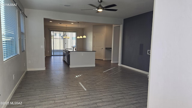 interior space with dark wood-style flooring, baseboards, and ceiling fan