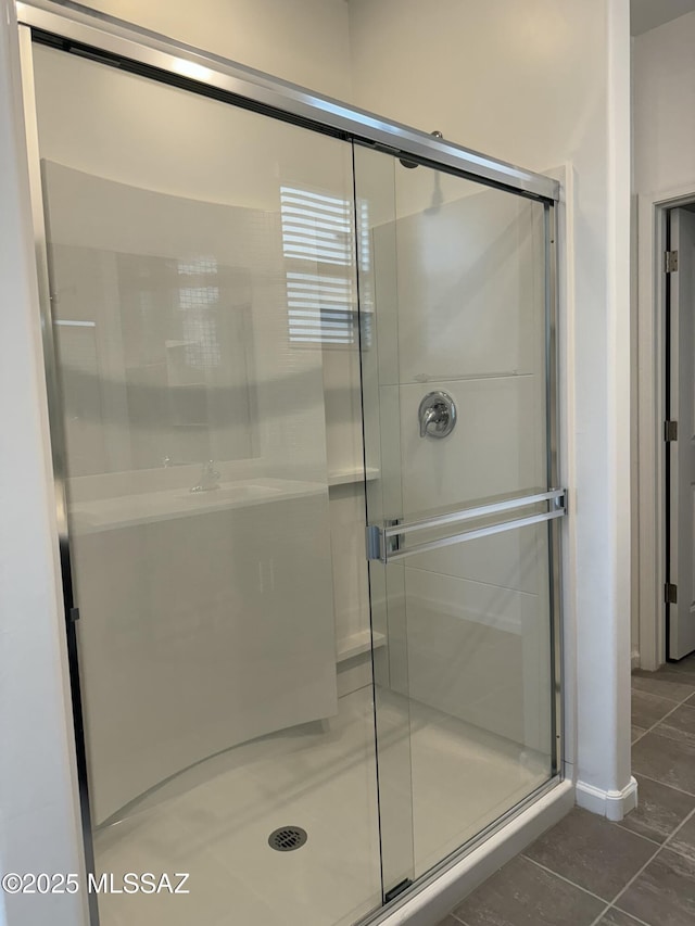 bathroom with tile patterned floors and a shower with door