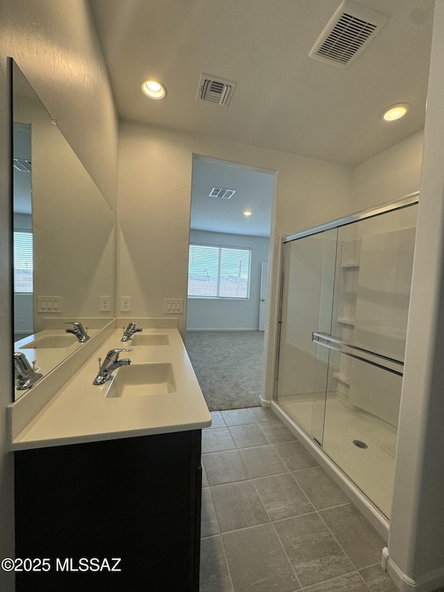 bathroom featuring tile patterned floors, vanity, and a shower with door