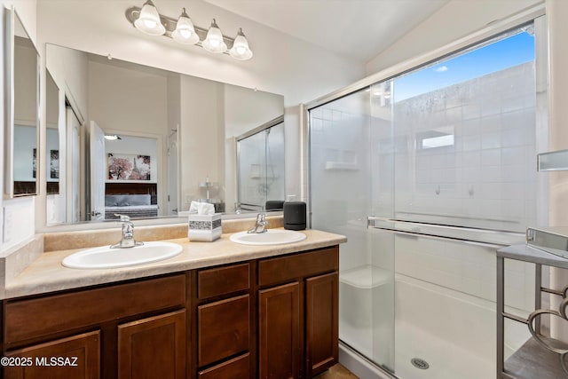 ensuite bathroom with a sink, a shower stall, double vanity, and connected bathroom