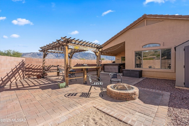 view of patio / terrace featuring an outdoor fire pit, a hot tub, a fenced backyard, and a pergola