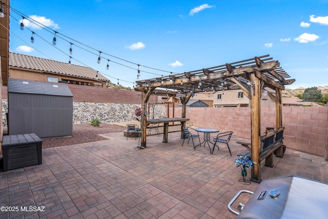 view of patio featuring a fenced backyard, a shed, an outdoor structure, and outdoor dining space