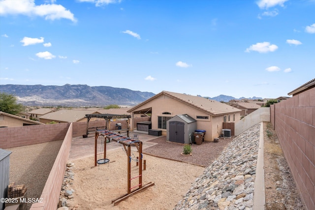 exterior space featuring a fenced backyard, a mountain view, a pergola, and a tiled roof