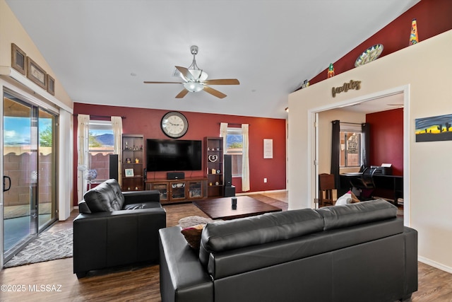 living area featuring lofted ceiling, baseboards, a ceiling fan, and wood finished floors