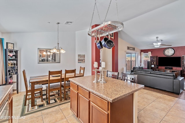 kitchen featuring lofted ceiling, open floor plan, light countertops, a center island, and pendant lighting