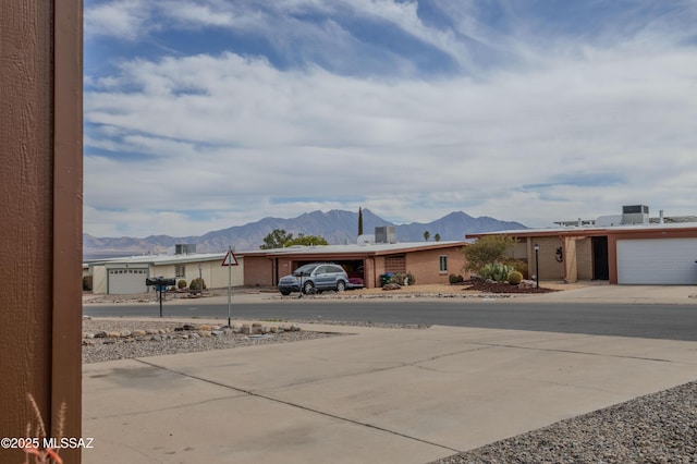 view of yard with concrete driveway and a mountain view