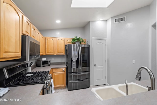 kitchen featuring visible vents, light countertops, a sink, stainless steel appliances, and a toaster