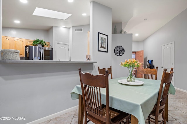 dining room with visible vents, light tile patterned floors, baseboards, recessed lighting, and a skylight