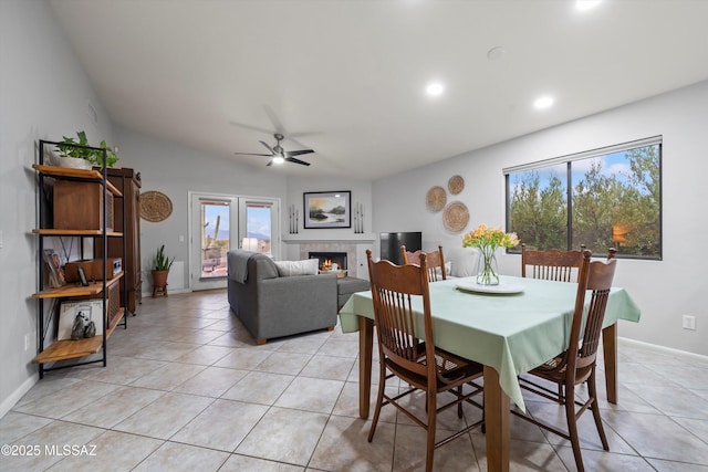 dining room with a fireplace, light tile patterned floors, and a healthy amount of sunlight