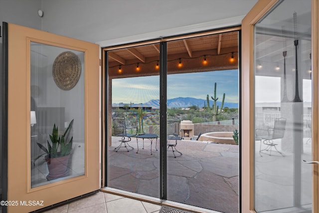 entryway featuring rail lighting, a wall of windows, and light tile patterned flooring