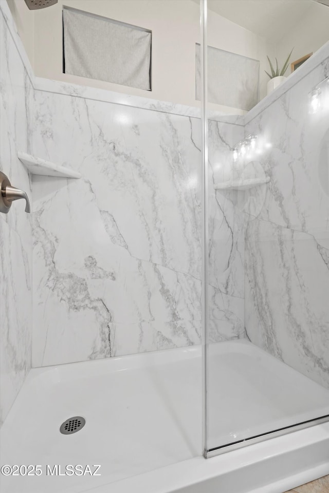 full bath with a marble finish shower