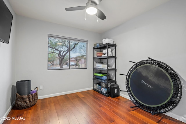 interior space with baseboards, ceiling fan, and wood finished floors