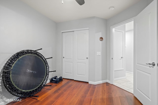 interior space with baseboards, a ceiling fan, and wood finished floors