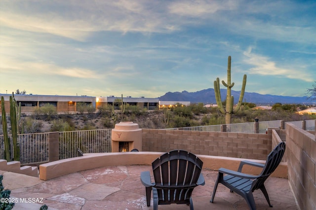 view of patio with a mountain view and fence