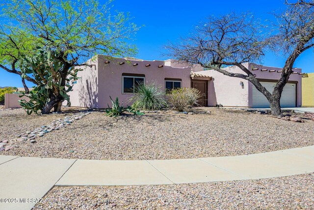 adobe home with stucco siding and a garage