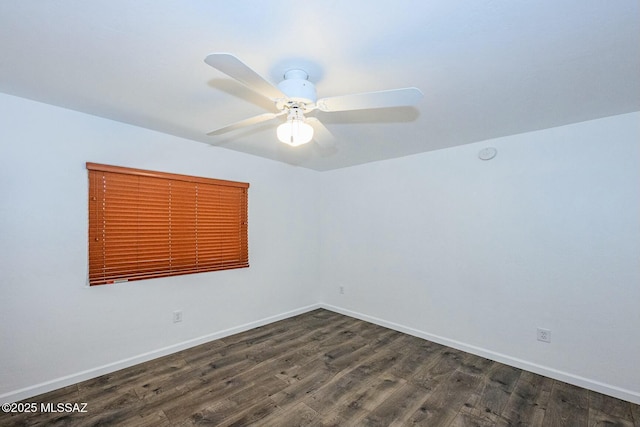 empty room featuring a ceiling fan, dark wood-style floors, and baseboards