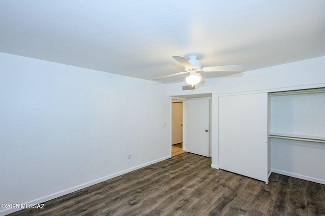 unfurnished bedroom featuring baseboards, visible vents, a closet, and wood finished floors