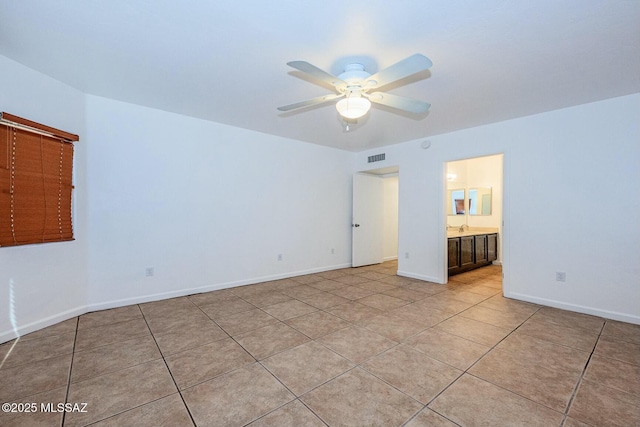 unfurnished bedroom with a sink, ensuite bathroom, light tile patterned floors, baseboards, and visible vents