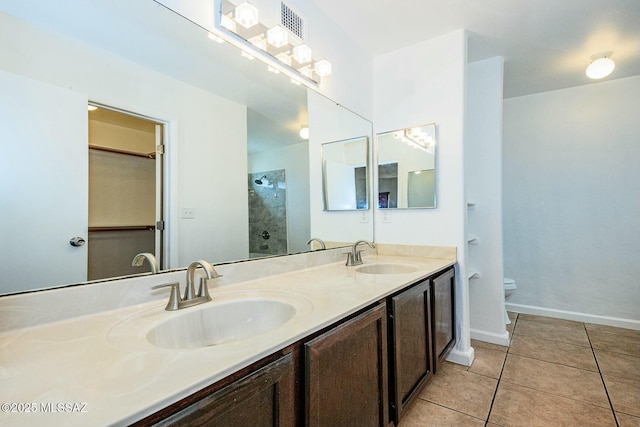 full bathroom with a sink, tile patterned floors, toilet, and a shower stall