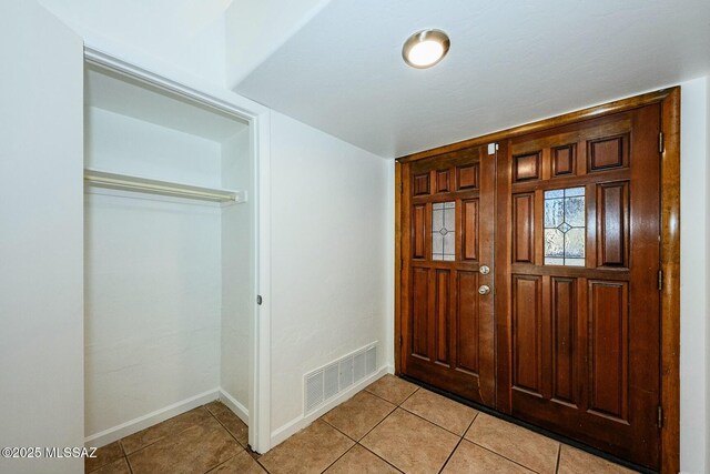 entrance foyer featuring baseboards, visible vents, and light tile patterned floors
