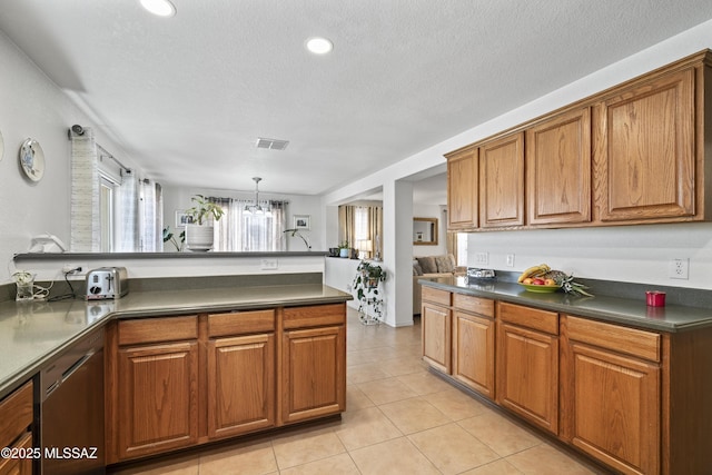 kitchen featuring hanging light fixtures, light tile patterned floors, and a textured ceiling