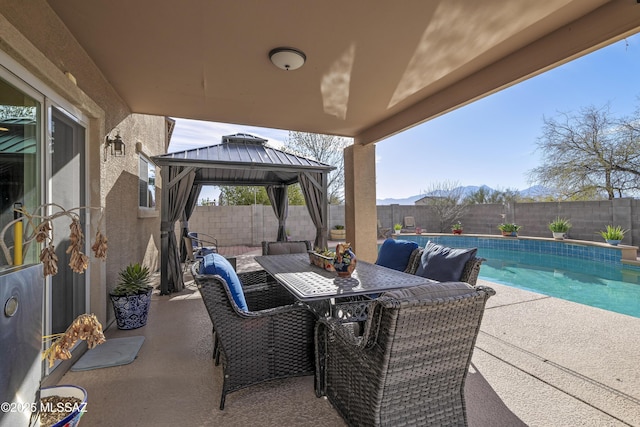 view of patio / terrace featuring a mountain view, a gazebo, and a fenced in pool