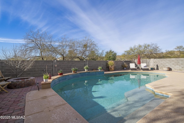 view of swimming pool featuring a patio area and a fire pit