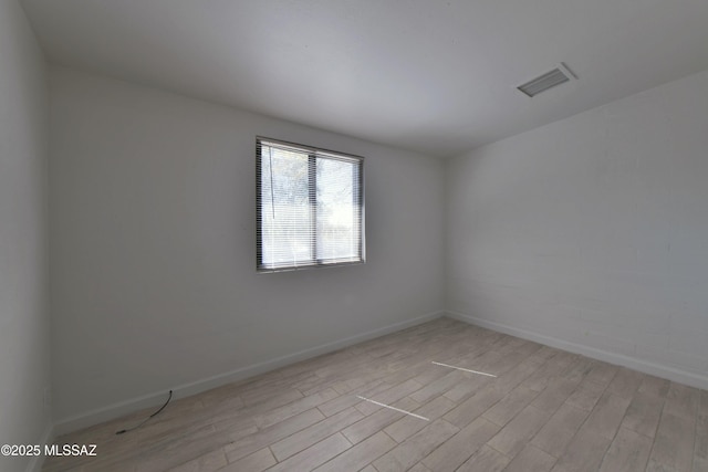 unfurnished room featuring baseboards, visible vents, and light wood finished floors