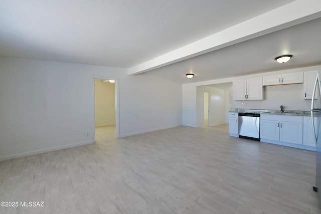 kitchen featuring baseboards, beam ceiling, stainless steel dishwasher, white cabinetry, and a sink