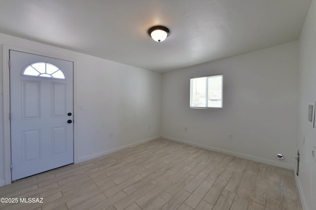 foyer with light wood finished floors and baseboards