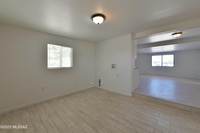 empty room featuring light wood finished floors and baseboards