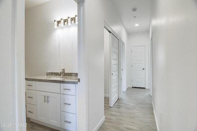 hall featuring sink and light hardwood / wood-style flooring