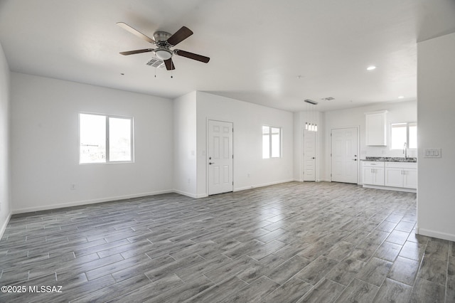 unfurnished living room with ceiling fan and light hardwood / wood-style floors