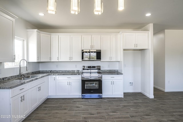 kitchen with decorative light fixtures, sink, stainless steel appliances, and white cabinets