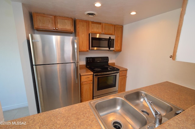 kitchen with sink, stainless steel appliances, and light tile patterned floors