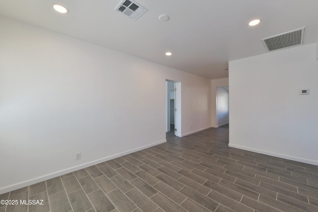 spare room with recessed lighting, visible vents, dark wood finished floors, and baseboards