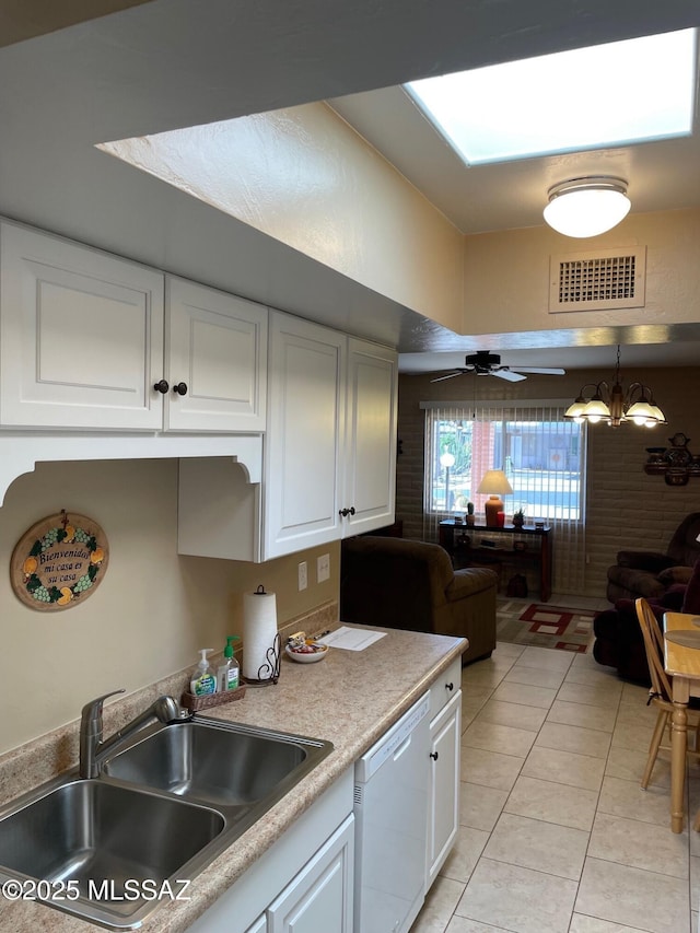 kitchen with visible vents, white dishwasher, a sink, and white cabinetry