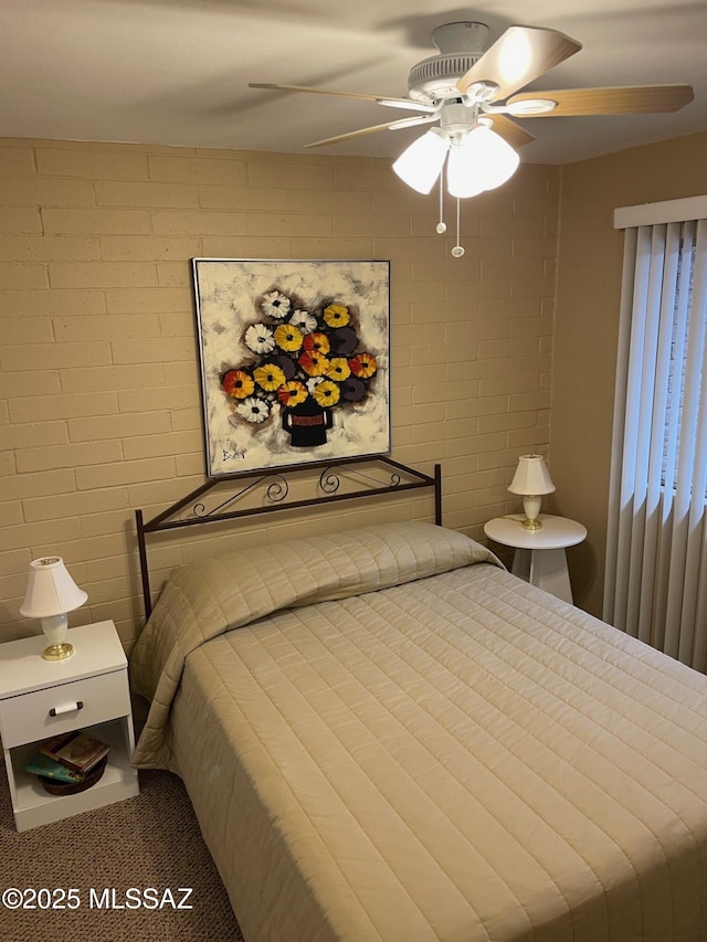 bedroom featuring brick wall and a ceiling fan