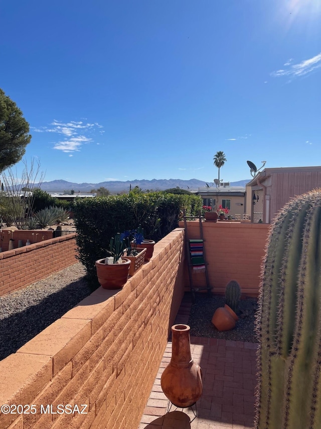 view of patio / terrace with fence and a mountain view