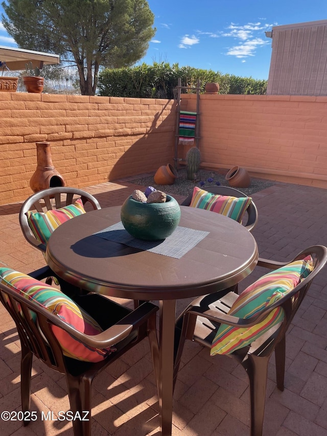 view of patio featuring outdoor dining area and fence