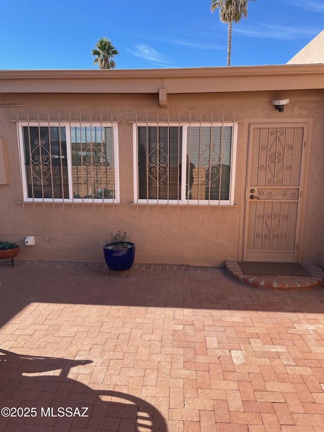 doorway to property featuring stucco siding