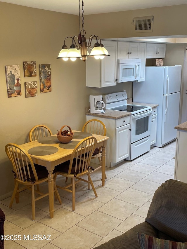 kitchen featuring visible vents, light countertops, white appliances, and white cabinetry