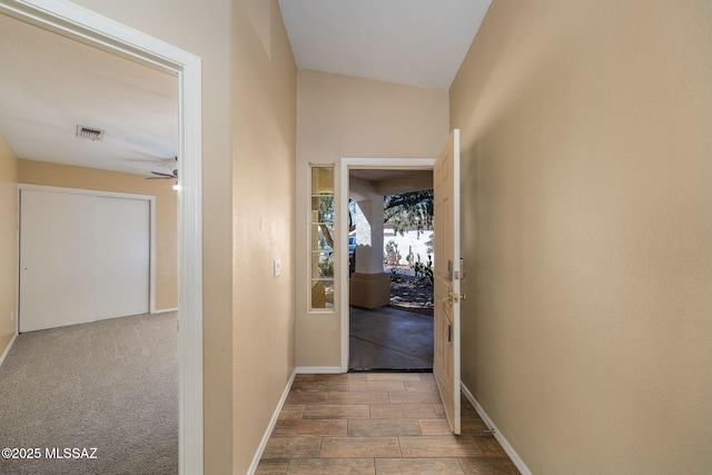 corridor with baseboards and visible vents