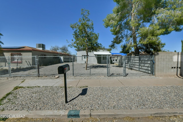 view of front facade with a fenced front yard, central AC unit, and a gate