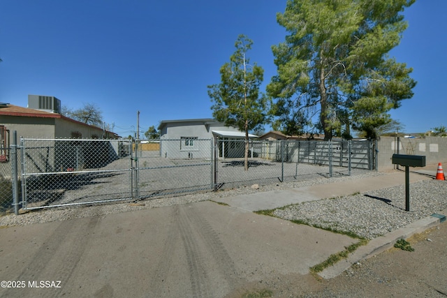 view of front of house with a gate, cooling unit, and stucco siding