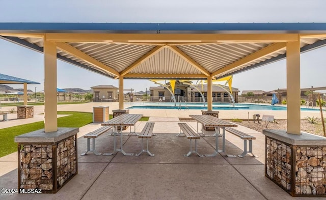 view of patio featuring a community pool and a gazebo