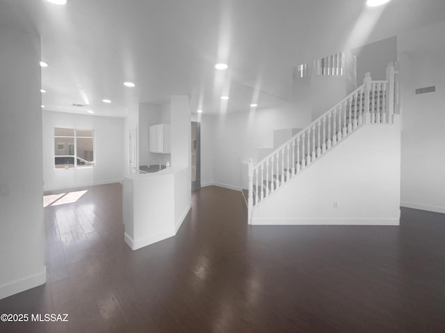 interior space with dark wood-style floors, recessed lighting, visible vents, stairway, and baseboards