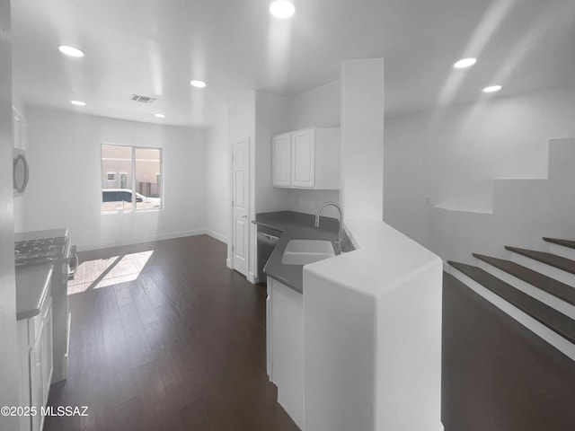 kitchen with a sink, visible vents, white cabinetry, black dishwasher, and dark countertops